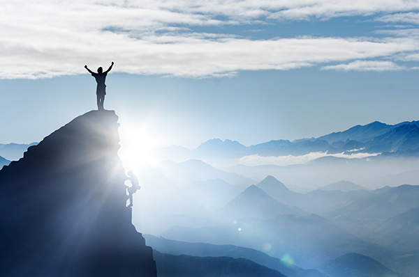 Homme ayant atteint son but au sommet d'une montagne